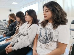 Alumnas cierran los ojos para meditar durante el “Taller meditación para la paz”, impartida por la Mtra. Itzel Mares. 